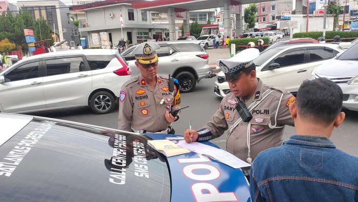 Polisi saat melakukan tilang kepada pengendara lalu lintas di Bandar Lampung.