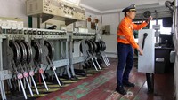 Petugas menurunkan palang kereta api di Stasiun Lidah Tanah. Stasiun ini dulunya berfungsi sebagai pengatur persilangan kereta api tujuan Medan-Tanjung Balai. Foto: ANTARA FOTO/Yudi Manar