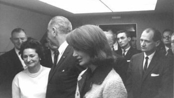 Foto ini diambil tepat setelah LBJ dilantik di Air Force One, tepat setelah kematian JFK . Di latar depan, Anda akan melihat Jackie Kennedy tampak berduka atas kehilangan suaminya. LBJ menoleh ke arah teman lamanya, anggota kongres Texas Albert Thomas, yang diam-diam mengedipkan mata dan tersenyum padanya. Foto: Boredpanda