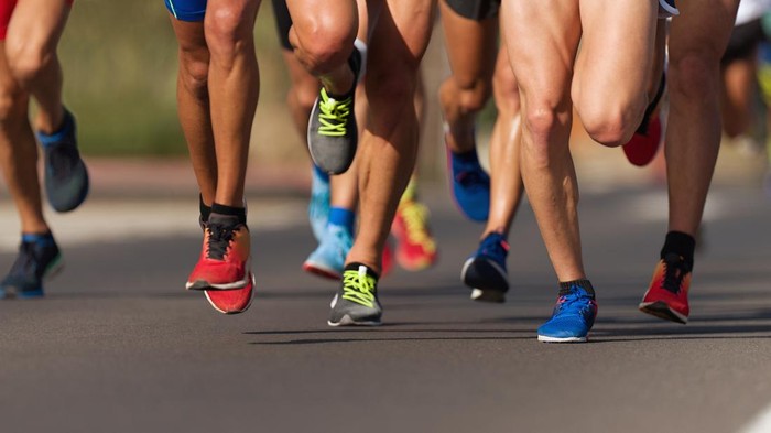 Marathon running race, people feet on city road