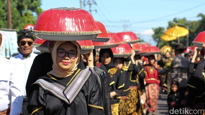 Iring-iringan pawai dulang dalam Festival Bejango Desa di Desa Anjani, Kecamatan Suralaga, Lombok Timur, NTB, Jumat (18/7/2025). (Foto: M Sanusi Ardi/detikBali)