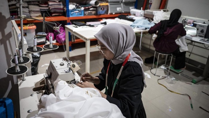Pekerja menjahit kain saat menyelesaikan pembuatan busana di salah satu butik di Ngaliyan, Semarang, Jawa Tengah, Jumat (18/7/2025). Kementerian Perindustrian memproyeksikan pertumbuhan rata-rata industri fesyen lokal sebesar 4,26 persen per tahun hingga 2029, dengan nilai pasar diperkirakan mencapai Rp156,47 triliun pada 2025. ANTARA FOTO/Aprillio Akbar/tom.