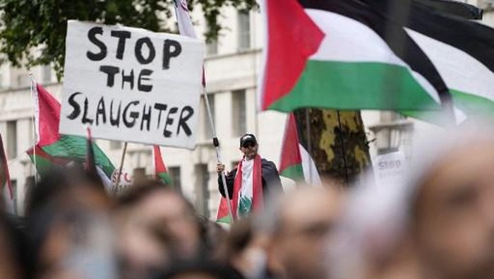 Pro-Palestinian supporters hold placards and wave flags on Downing Street in central London, on July 19, 2025, as they take part in a National March for Palestine organised by the Palestine Solidarity Campaign. (Photo by CARLOS JASSO / AFP)
