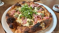 Layaknya restoran Eropa, menu pizza juga tersedia di Cru Corner Bistro. Stracciatella Pizza (Rp 158 ribu) dapat dicoba dengan topping ham daging sapi, krim parmesan, pesto pistachio, dan daun rocket alias arugula. Foto: Andi Annisa DR/detikfood