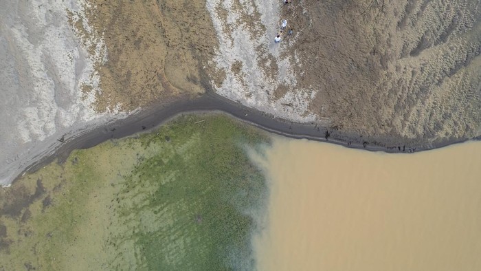 Fenomena Langka! Sungai Batanghari Surut, Dasarnya Jadi Tempat Nongkrong Foto udara warga bermain di Sungai Batanghari yang mengalami penyusutan debit air di Penyengat Rendah, Jambi, Sabtu (19/7/2025). Sungai terpanjang di Sumatra itu menyusut akibat kemarau yang terjadi sejak dua bulan terakhir dan mengakibatkan sejumlah titik sungai mengering hingga seluas sekitar 10 hektare. ANTARA FOTO/Wahdi Septiawan