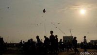 Di langit senja, warna-warni layangan saling beradu ketangkasan. Para pemain melakukan sambitan atau duel antar layangan untuk saling menjatuhkan. 