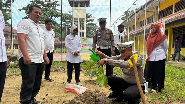 Polres Kuansing mengakal para siswa SMKN 1 Teluk Kuantan menanam pohon, Minggu (20/7/2025).