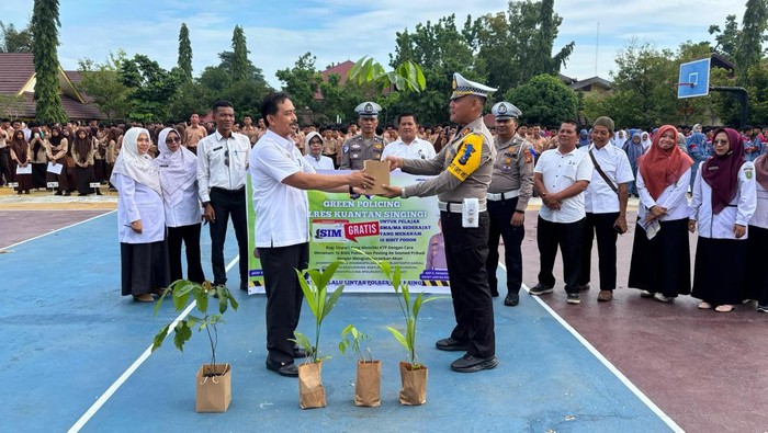 Polres Kuansing mengakal para siswa SMKN 1 Teluk Kuantan menanam pohon, Minggu (20/7/2025).