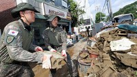 Di Gwangju, tim relawan dan tentara Korea Selatan dikerahkan untuk membantu membersihkan kawasan yang terdampak banjir. Mereka bekerja keras memindahkan puing-puing dan lumpur dari jalanan dan rumah-rumah warga. Kondisi terparah terjadi di area permukiman padat penduduk yang airnya mencapai ketinggian lutut hingga pinggang. REUTERS/Yonhap News Agency