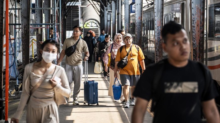Penumpang berjalan menuju gerbong kereta api Tawang Jaya Premium di Stasiun Semarang Tawang, Semarang, Jawa Tengah, Minggu (20/7/2025). PT Kereta Api Indonesia (Persero) mencatat hingga 18 Juli 2025 sebanyak 3.003.636 lembar tiket telah terjual dari total 3.529.612 kursi promo yang merupakan bagian dari program diskon 30 persen untuk kereta api ekonomi komersial, sebagai upaya pemerintah dalam memberikan stimulus dalam mendorong mobilitas masyarakat melalui penggunaan transportasi publik. ANTARA FOTO/Aprillio Akbar
