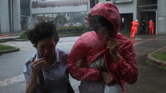 Topan Wipha Terjang Hong Kong, Warga Bertahan di Tengah Badai Topan Wipha melanda wilayah Hong Kong pada Minggu (20/7/2025), disertai hujan deras dan angin kencang yang memaksa aktivitas kota nyaris lumpuh. Sejumlah pohon tumbang menutup jalanan, sementara pejalan kaki terpaksa berjalan tertatih di tengah badai, berusaha melindungi diri dengan payung yang tak mampu menahan kuatnya tiupan angin. REUTERS/Tyrone Siu