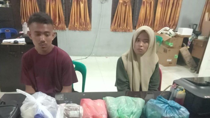 Kedua pelaku saat diamankan di kantor polisi.