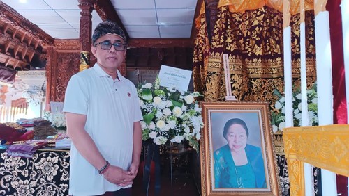 Wali Kota Denpasar I Gusti Ngurah Jaya Negara saat berfoto di samping foto sang ibunda yang telah berpulang, Ni Jero Samiarsa pada Minggu (20/7/2025)