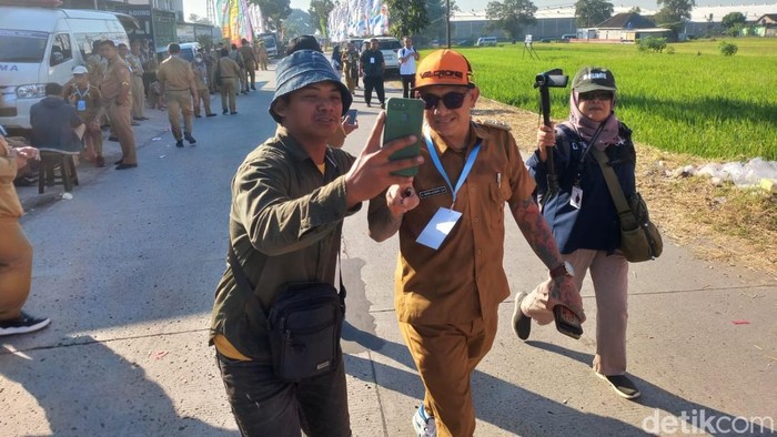 Dua kades nyentrik, Kades Blangu, Sragen, Danang Wijaya (berambut gimbal) dan Kades Purwasaba, Banjarnegara, Hoho Alkaf (bertato) di peluncuran Kopdes Merah putih di Desa Bentangan, Wonosari, Klaten, Senin (21/7/2025).