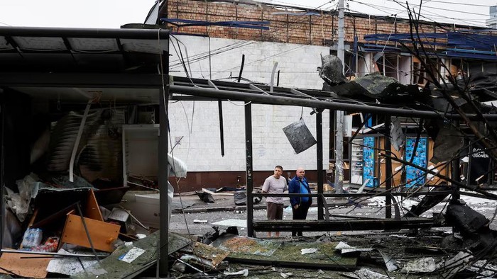 People look at a damaged bus stop outside the metro station that was damaged during the night due to Russian drone and missile strikes, amid Russias attack on Ukraine, in Kyiv, Ukraine July 21, 2025. REUTERS/Thomas Peter Purchase Licensing Rights