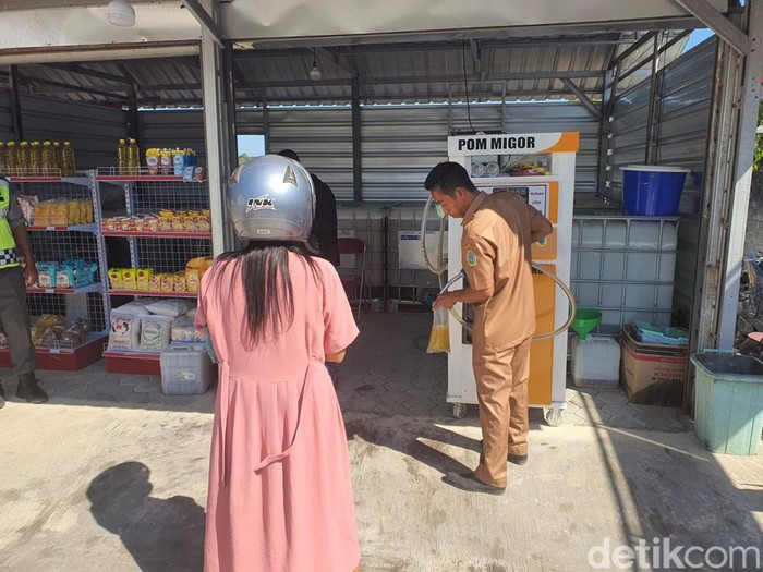 Warga saat membeli minyak goreng yang dicurahkan dari alat mirip POM mini di Kopdes Merah Putih di Playen, Gunungkidul, Senin (21/7/2025).