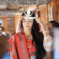 Dalam salah satu foto, Krisdayanti tampak sedang dipasangkan mahkota logam di atas kepalanya. Mahkota tersebut memiliki bentuk unik menyerupai bulan sabit. Foto: Instagram/@krisdayantilemos