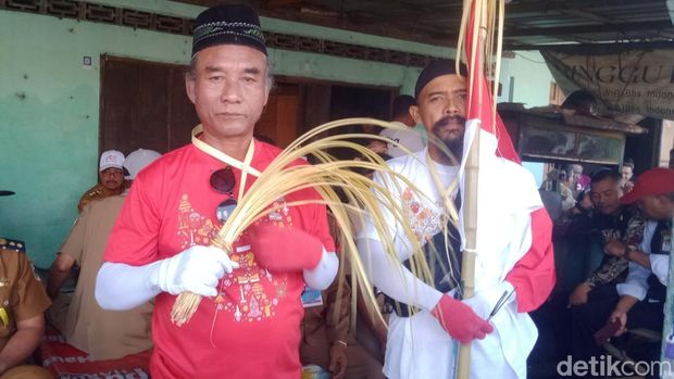 Dua orang menyambut presiden dengan membawa janur dan hio di Desa Bentangan, Klaten, Senin (21/7/2025).