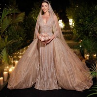 Tak sampai d situ, Elie Saab membuatkan gaun ketiga untuk perayaan cinta anak dan menantunya. Untuk pesta, Zein mengenakan gaun V-neck bernuansa cokelat dengan rok sepanjang 4,5 meter dan dihiasi bordir, kristal, payet, dan batu-batu berlian gemerlapan. Foto: Instagram @zein_qutami