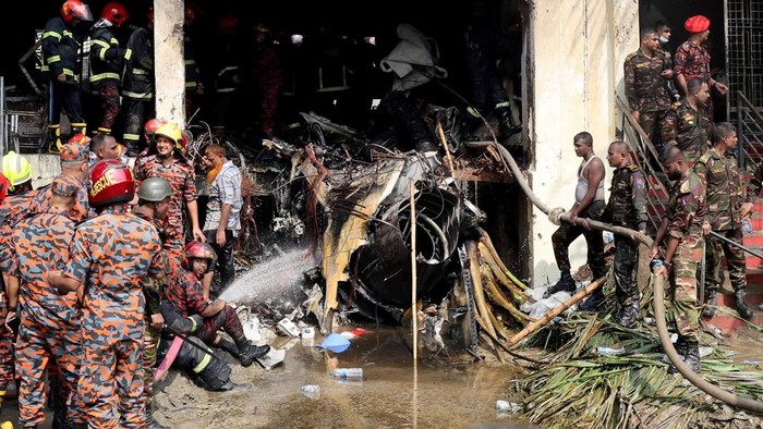 Firefighters and army members work next to the wreckage of an air force training aircraft after it crashed into Milestone College campus, in Dhaka, Bangladesh, July 21, 2025. REUTERS/Stringer     TPX IMAGES OF THE DAY