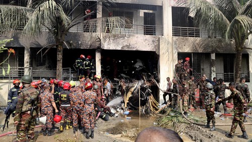 Firefighters and army members work next to the wreckage of an air force training aircraft after it crashed into Milestone College campus, in Dhaka, Bangladesh, July 21, 2025. REUTERS/Stringer     TPX IMAGES OF THE DAY