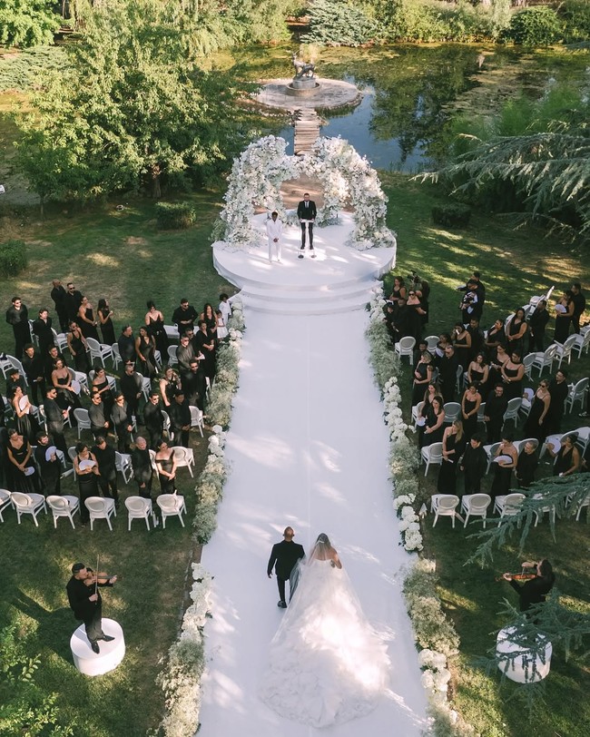 Pesta pernikahan Endrick dan Gabriely hanya dihadiri oleh keluarga serta teman dekat. Pesta digelar dengan dress code monokrom. Para tamu pun mengenakan pakaian serba hitam, sementara mempelai pria dan wanita tampil dengan busana pengantin putih yang senada dengan dekorasi bunga. Foto: Dok. Instagram @endrick @gabriely