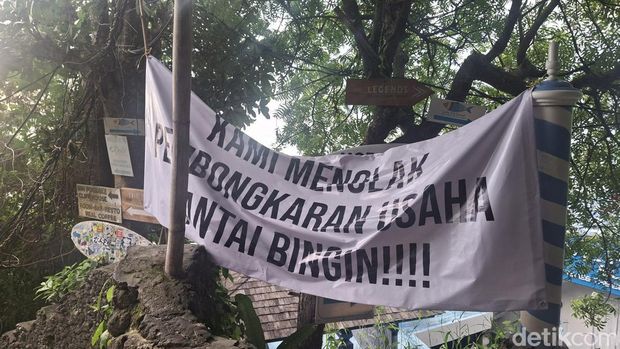 Spanduk penolakan pembongkaran bangunan ilegal di Pantai Bingin, Badung, Senin (21/7/2025).