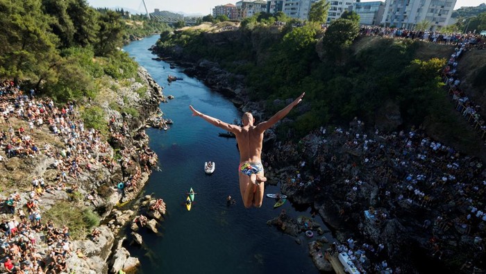Tradisi Uji Nyali Lompat dari Jembatan 23 Meter di Montenegro An athlete jumps from 23-meter-high Vizier bridge over Moraca river after 15 years of pause in traditional high diving competition in Podgorica, Montenegro, July 19, 2025. REUTERS/Stevo Vasiljevic REFILE - CORRECTING YEAR FROM
