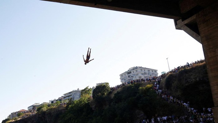 An athlete jumps from 23-meter-high Vizier bridge over Moraca river after 15 years of pause in  traditional high diving competition in Podgorica, Montenegro, July 19, 2025. REUTERS/Stevo Vasiljevic  REFILE - CORRECTING YEAR FROM 