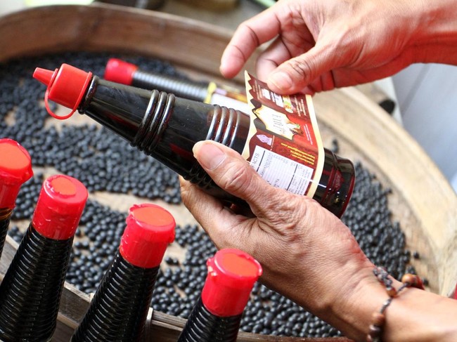 Pelaku Usaha Mikro Kecil Menengah (UMKM) mengemas kecap sehat berbahan kedelai lokal yang diproduksi tanpa bahan kimia di industri rumahan kecap Tugu Jawa, Malang, Jawa Timur, Selasa (22/7/2025). UMKM binaan Rumah Badan Usaha Milik Negara (BUMN) itu mendapat pendampingan serta pelatihan digital marketing yang mendorong peningkatan produksi dari 300 liter menjadi satu ton per bulan dalam lima tahun terakhir sehingga kini mampu diekspor ke Hongkong maupun dijual secara daring ke berbagai daerah di Indonesia dengan harga Rp7 ribu hingga Rp10 ribu per botol tergantung varian. ANTARA FOTO/Ari Bowo Sucipto/foc.
