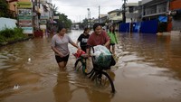 Sejumlah warga membawa barang-barang penting saat dievakuasi dari desa yang terendam banjir di Cainta, Rizal, Filipina. REUTERS/Eloisa Lopez