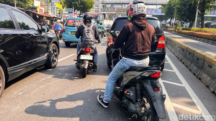 Pengendara melintas di Jalan Gunung Sahari, Jakarta, Senin (21/7/2025). Sejumlah motor terlihat tanpa pelat nomor belakang.