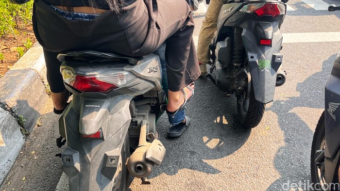 Pengendara melintas di Jalan Gunung Sahari, Jakarta, Senin (21/7/2025). Sejumlah motor terlihat tanpa pelat nomor belakang.