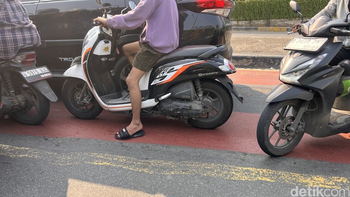 Pengendara melintas di Jalan Gunung Sahari, Jakarta, Senin (21/7/2025). Sejumlah motor terlihat tanpa pelat nomor belakang.
