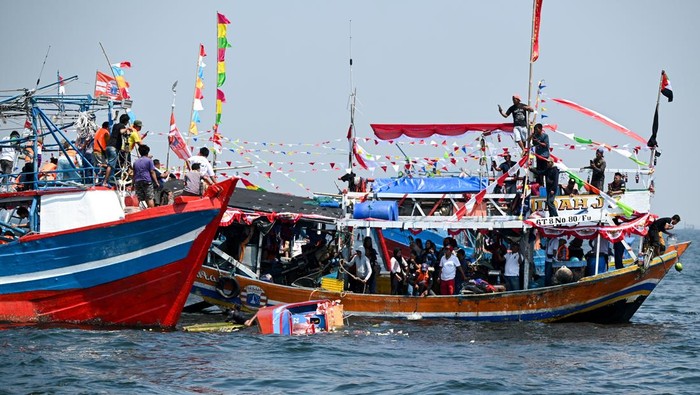 Warga berada di atas kapal saat mengikuti pelepasan sesajen ke laut dalam tradisi sedekah laut Nadran nelayan Muara Angke di Jakarta, Selasa (22/7/2025). Nelayan di Muara Angke menggelar tradisi Nadran atau sedekah laut sebagai bentuk ungkapan rasa syukur atas hasil laut yang mereka peroleh. ANTARA FOTO/Fauzan/foc.