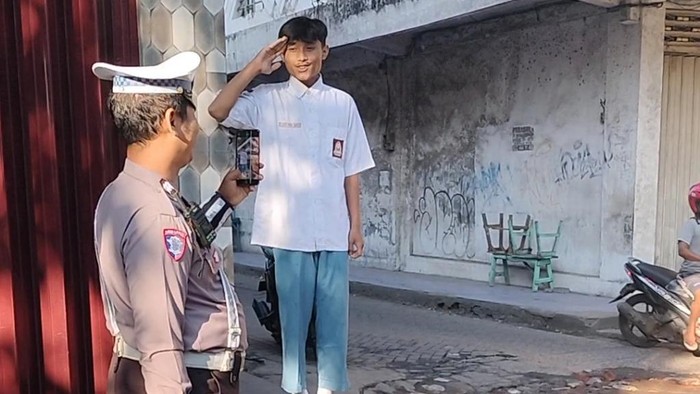 Pelajar SMA dihukum nyanyi Lagu Indonesia Raya dengan sikap hormat kepada pengguna jalan yang tertib.