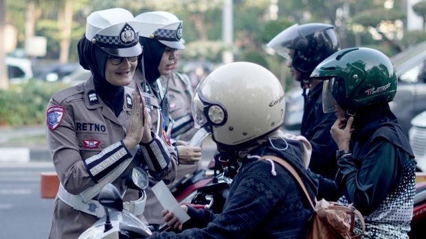 Polisi di Surabaya bagikan helm untuk anak yang dibonceng orang tuanya.