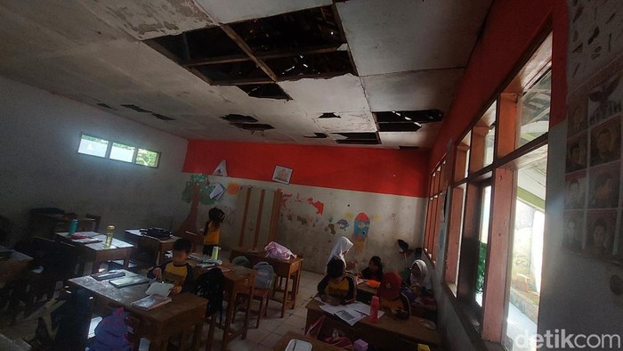 Siswa SD belajar di ruang kelas yang atapnya bolong-bolong