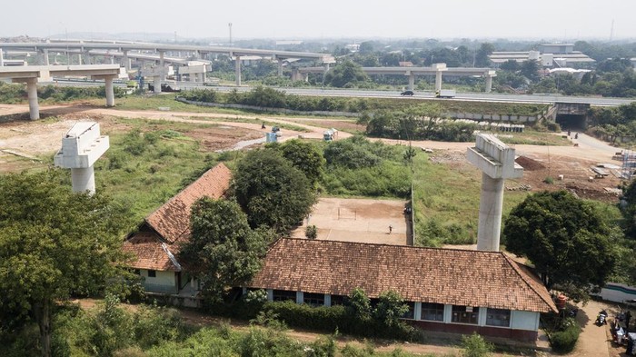 Terdampak Proyek Tol, SDN Burangkeng 04 Bakal Direlokasi Foto udara bangunan SDN Burangkeng 04 yang terletak di dekak proyek Jalan Tol Jakarta-Cikampek seksi II di Setu, Kabupaten Bekasi, Jawa Barat, Selasa (22/7/2025). Menurut keterangan guru, orang tua murid mengeluhkan lokasi bangunan sekolah yang belum direlokasi ke tempat yang baru dan berdampak pada penurunan minat murid baru yang mendaftar ke sekolah tersebut pada tahun ajaran 2025/2026 yang hanya mendapatkan 47 murid. ANTARA FOTO/ Fakhri Hermansyah/rwa.
