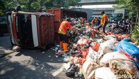 Sebuah truk bermuatan sampah terguling di fly over Unisma, Bekasi, Selasa (22/7/2025).