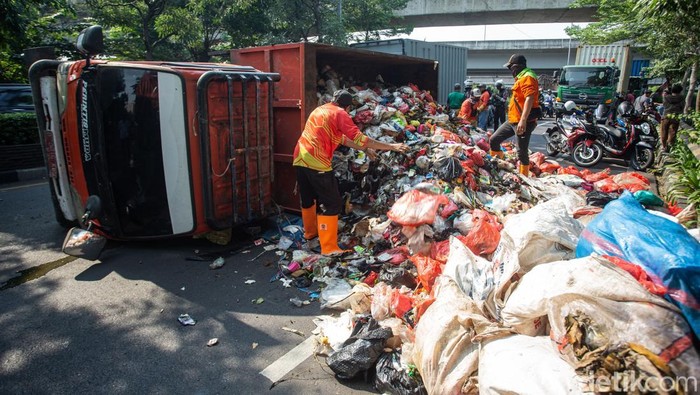 Truk sampah terguling di flyover Unisma, Bekasi, Kamis (22/7). Muatan tumpah ke jalan dan sebabkan kemacetan arah Bekasi Barat.