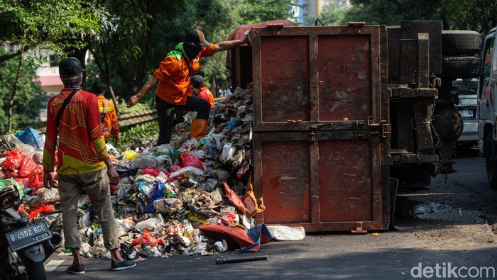 Truk sampah terguling di flyover Unisma, Bekasi, Kamis (22/7). Muatan tumpah ke jalan dan sebabkan kemacetan arah Bekasi Barat.