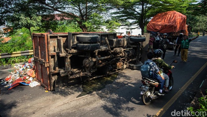 Truk Sampah Terbalik, Sampah Berserakan di Flyover Unisma Truk sampah terguling di flyover Unisma, Bekasi, Kamis (22/7). Muatan tumpah ke jalan dan sebabkan kemacetan arah Bekasi Barat.