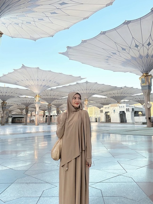 Anissa Aziza mengabadikan dengan momen latar belakang masjid Nabawi, Madinah. Ia terlihat anggun memakai abaya warna milo lengkap dengan hijab pashmina instan yang dibentuk syari. Foto: Dok. Instagram @anissaaziza.