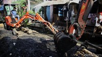Petugas mengoperasikan alat berat ukuran kecil untuk mengeruk lumpur di aliran Kali Krukut, Kebon Melati, Tanah Abang, Jakarta, Rabu (23/7/2025).