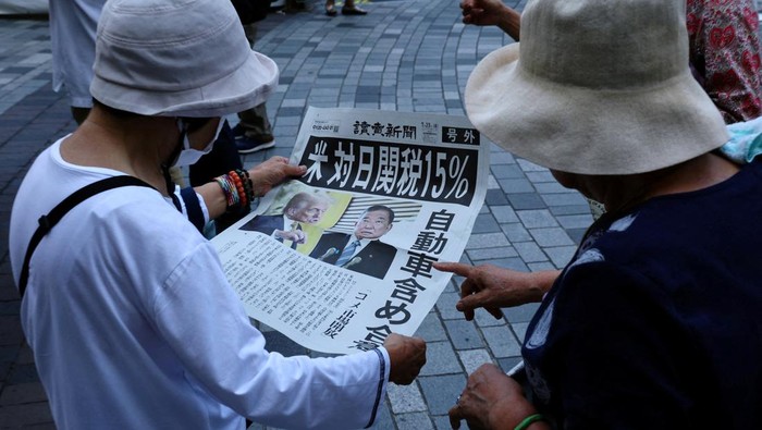 AS Turunkan Tarif Impor Jepang Jadi 15 Persen People react as they read a special edition of Yomiuri Shimbun newspaper reporting the tariff deal agreement between U.S and Japan, in Tokyo, Japan, July 23, 2025. REUTERS/Kim Kyung-Hoon TPX IMAGES OF THE DAY