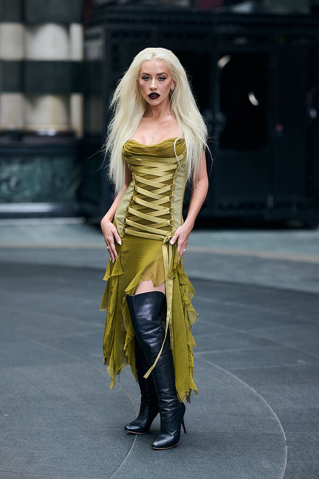 Christina Aguilera memaksimalkan gaya gothic dengan memadukan gaun korset tersebut bersama sepatu bot hitam dan riasan gelap bak rocker. Foto: Gareth Cattermole/Getty Images/Gareth Cattermole