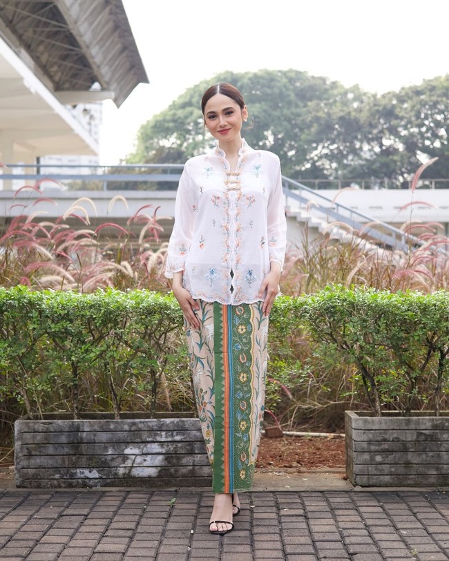 Syifa Hadju tampil anggun dengan padanan kebaya encim putih bordir bunga yang dipadukan kain Batik hijau khas Pekalongan. Cocok untuk perayaan Hari Kebaya Nasional atau momen formal di siang hari. Foto: Instagram/@syifahadju