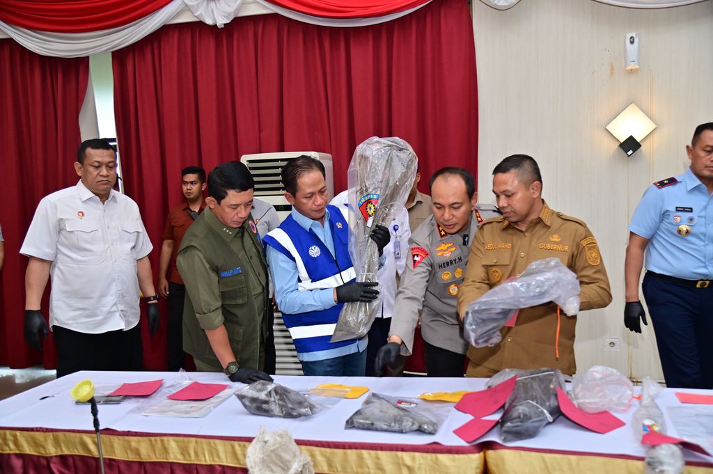 Kepala BNPB Letjen TNI Dr. Suharyanto, S. Sos., M.M., (kemeja dan rompi hijau) saat melihat barang bukti dan tersangka pembakar hutan pada Rapat Koordinasi Penanganan Kebakaran Hutan dan Lahan di Gedung Serindit, Kota Pekanbaru, Provinsi Riau pada Selasa (22/7). (Dok. BNPB)