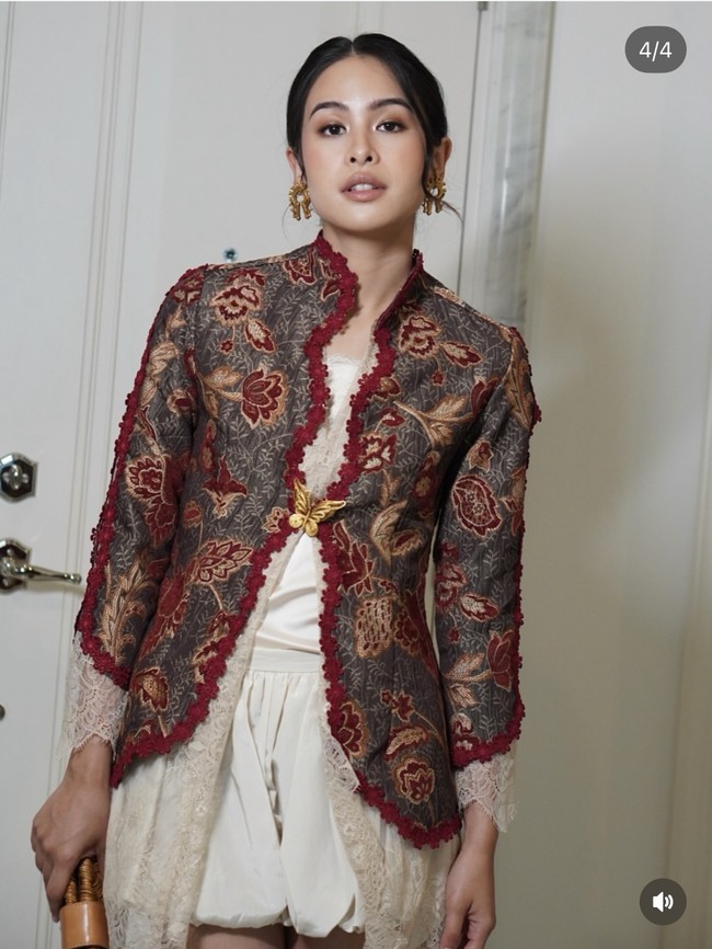 Maudy Ayunda tampil edgy dengan kebaya modifikasi lengan panjang. Inner berupa kain brokat transparan dipadukan dengan siluet kebaya kerah tinggi bermotif bunga besar warna coklat, merah, dan keemasan. Sebagai bawahan, Maudy mengenakan rok balon mini warna putih. Foto: Instagram